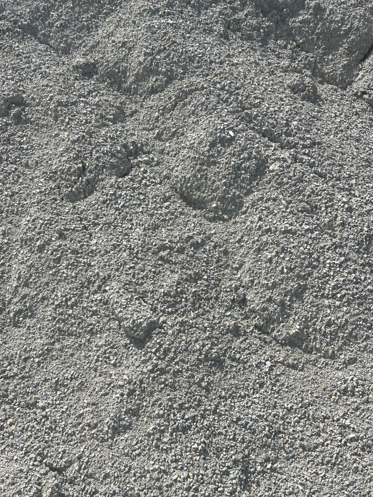 Gray gravel with visible footprints.