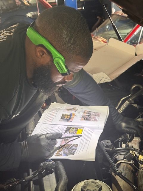 Close-up, low-angle, black-and-white view of the heavy-duty suspension and large, treaded tires of an off-road truck.