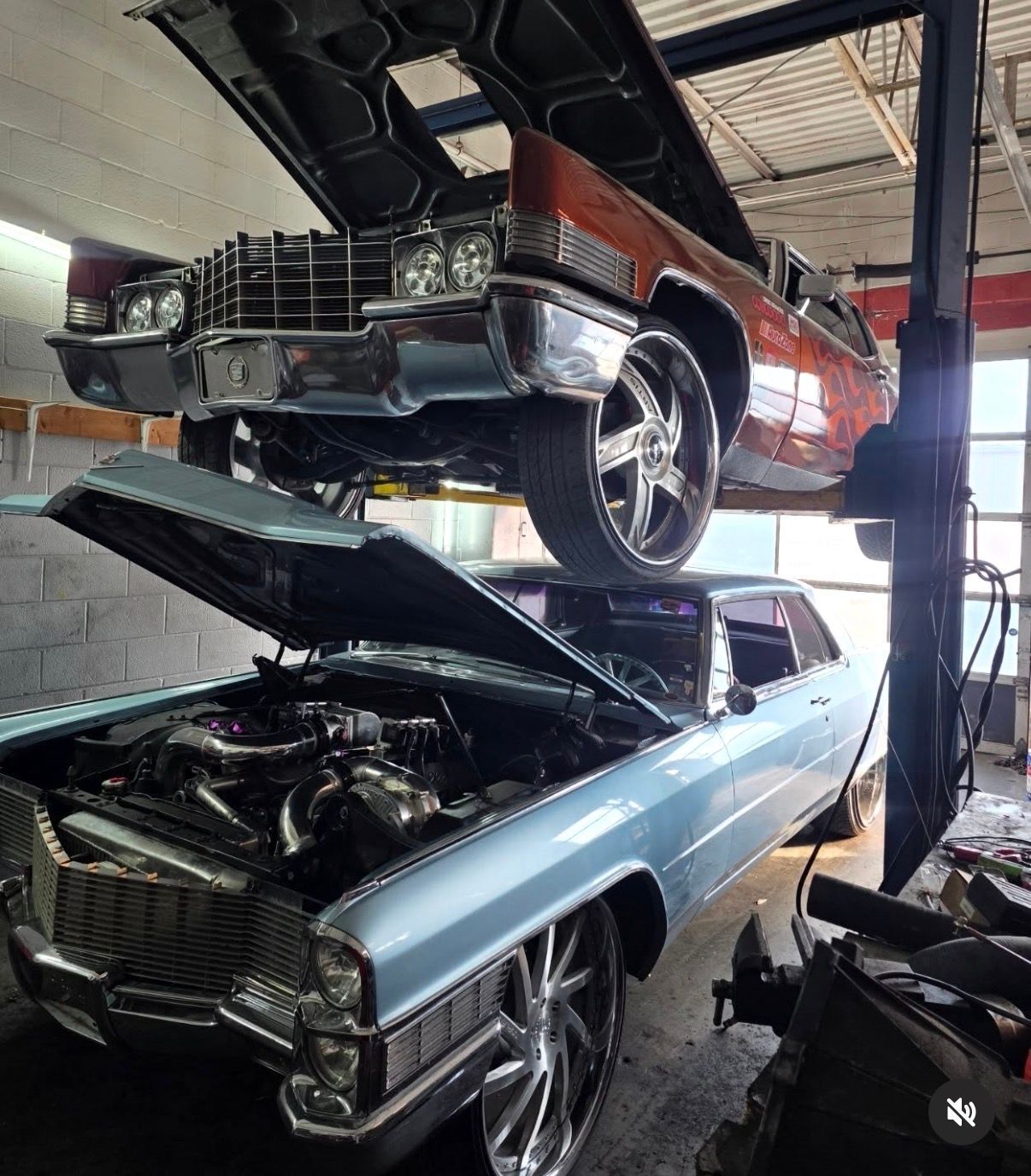 A black and white low-angle view of the large, rugged tires and exposed suspension system of a modified off-road vehicle.