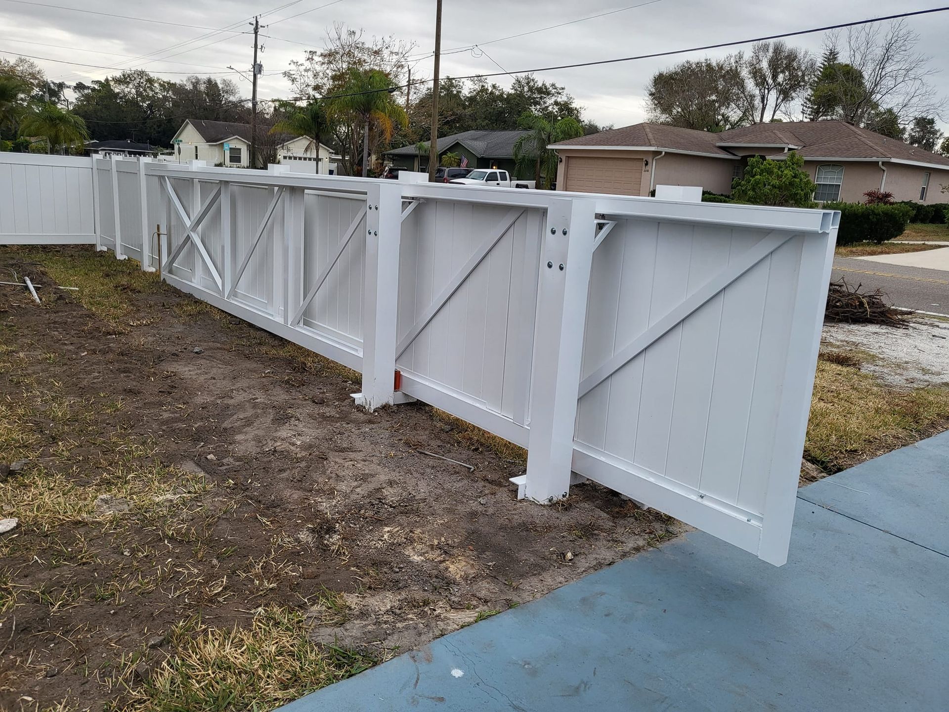 A white fence is sitting on the side of a road.