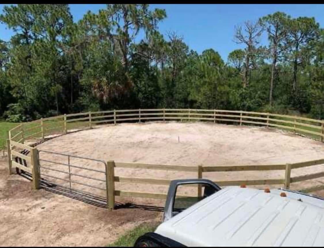 A white truck is parked in front of a wooden fence.