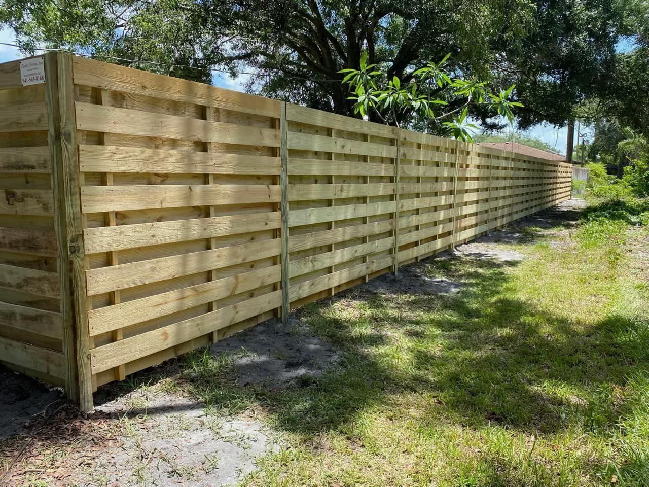 A wooden fence is sitting in the middle of a grassy field.