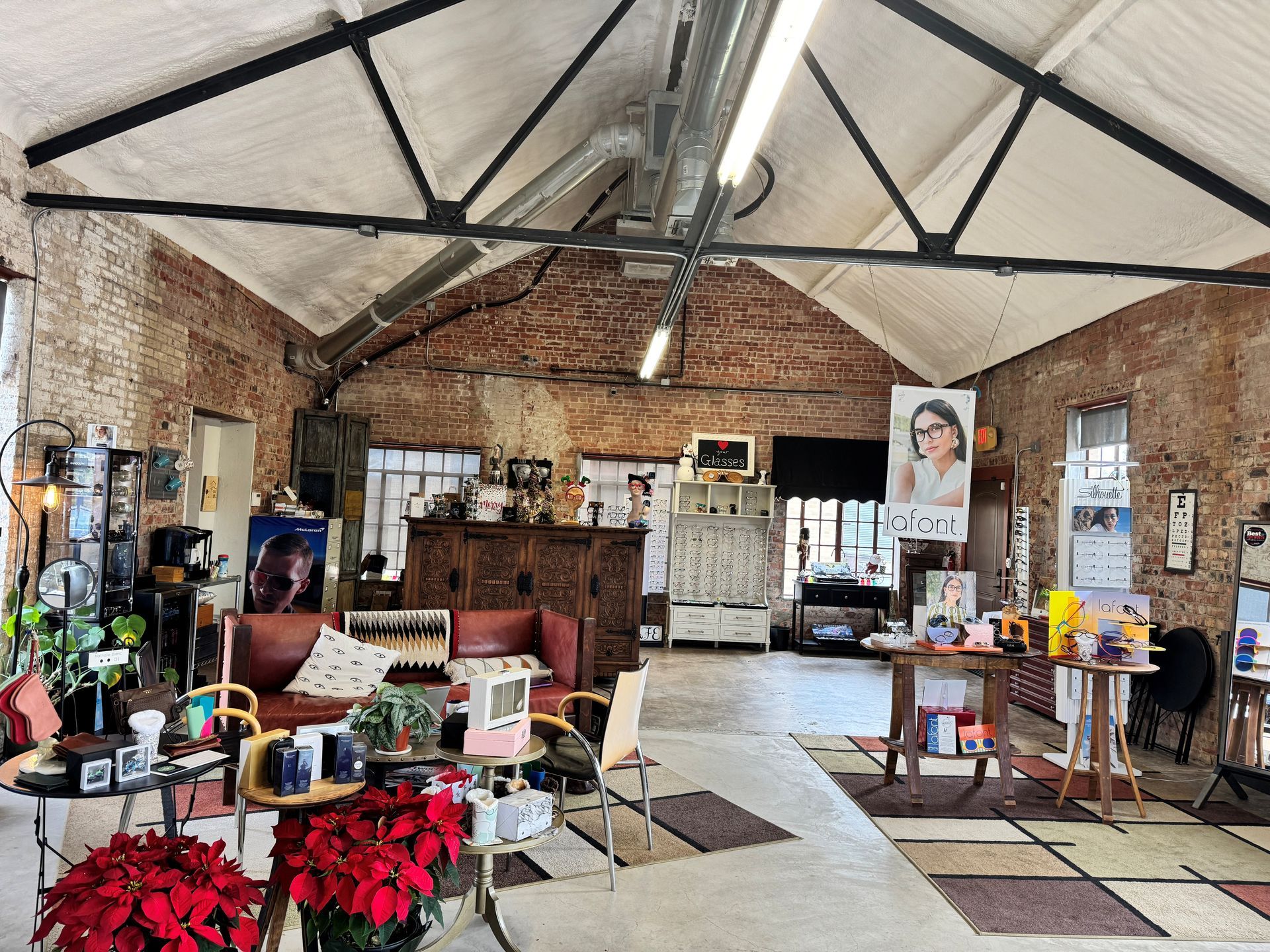 Interior of a shop with exposed brick walls, a vaulted ceiling, and various displays of items.