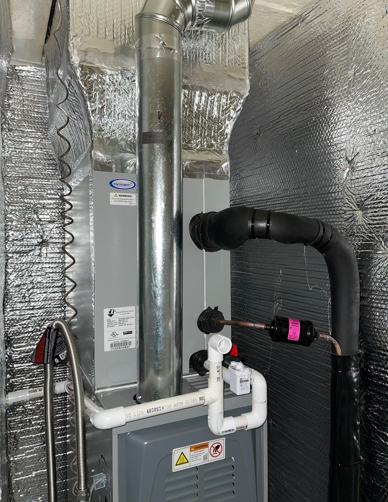 Furnace with insulated ductwork and piping in an enclosed space.