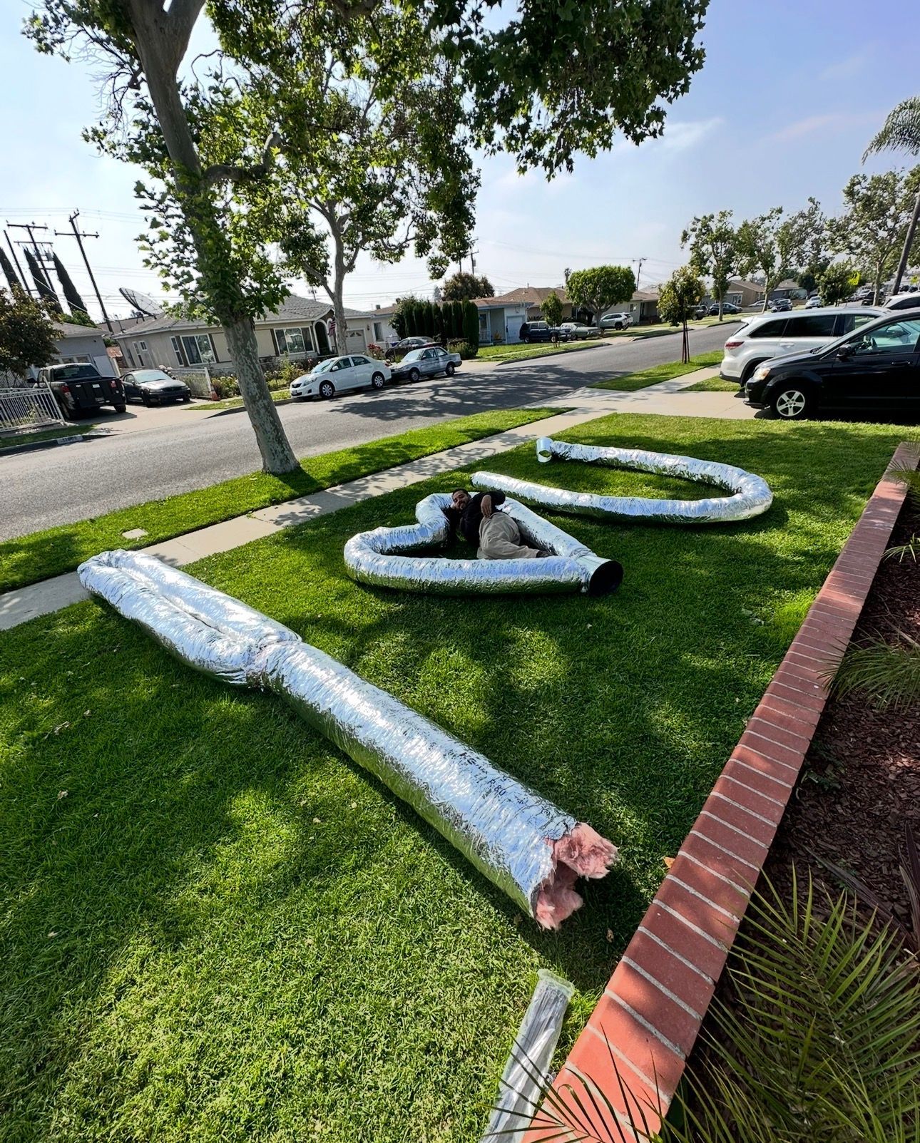 Large silver air ducts arranged on lawn spelling 