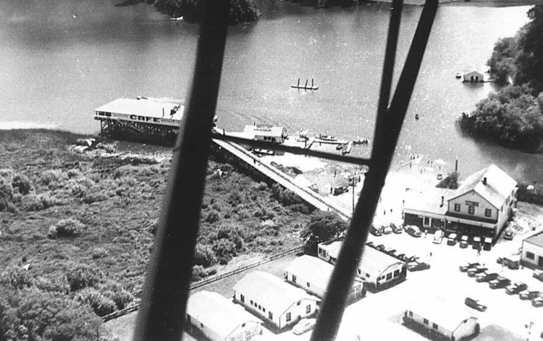 aerial view of a pier with buildings and docked boats on a body of water