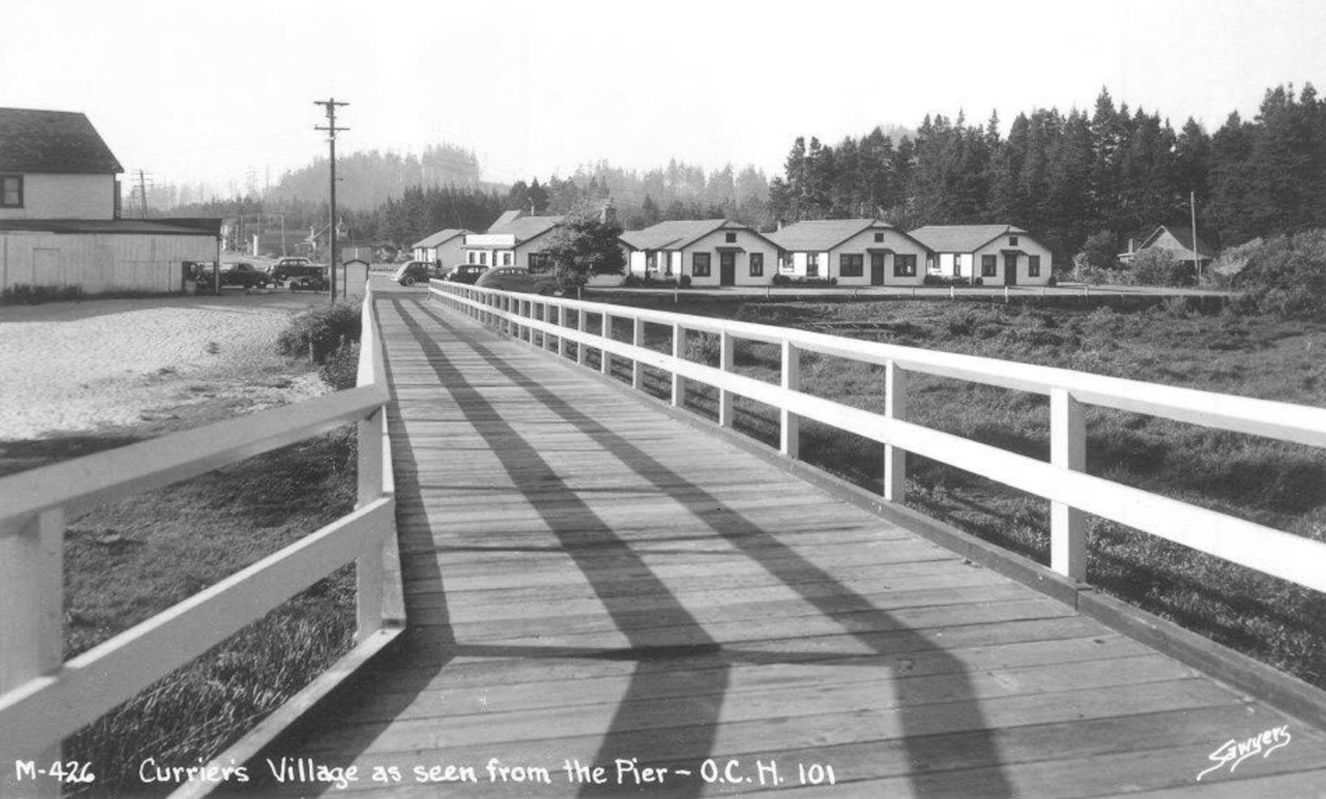 wooden bridge leads to a village, seen from a pier