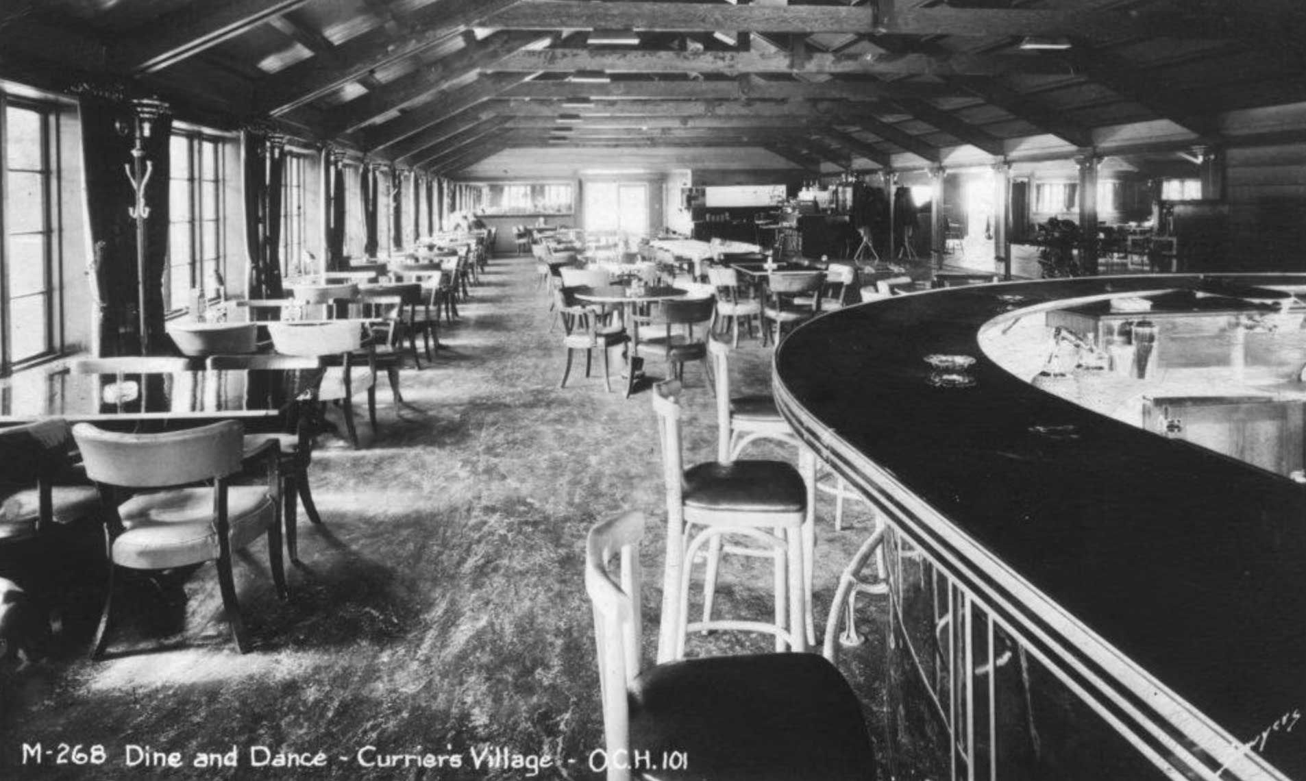 interior of a lounge with tables and a curved bar