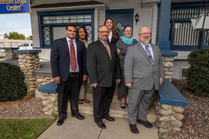 A group of people are posing for a picture in front of a building.