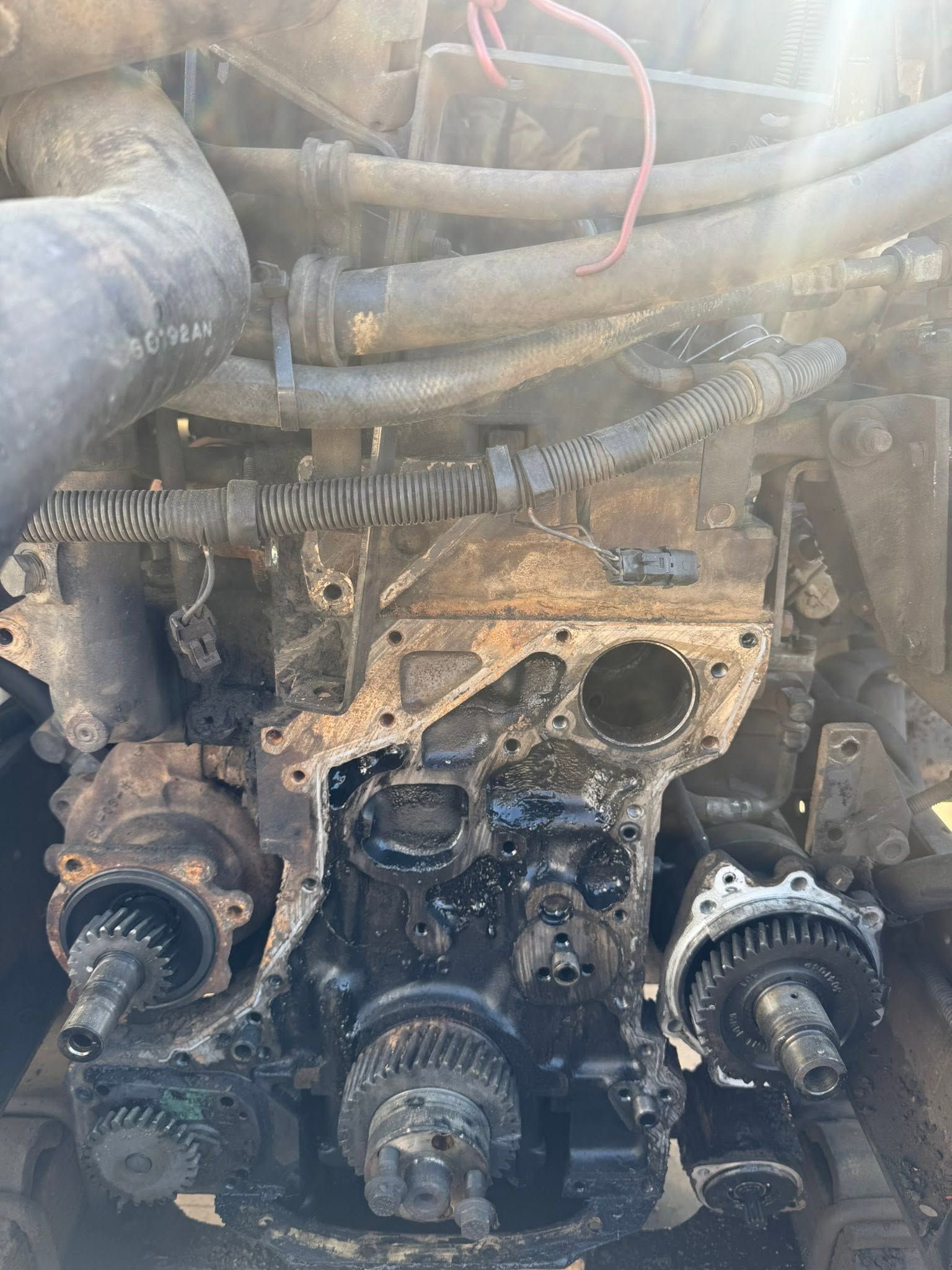 Dirty engine block with hoses and gears exposed in a mechanical bay