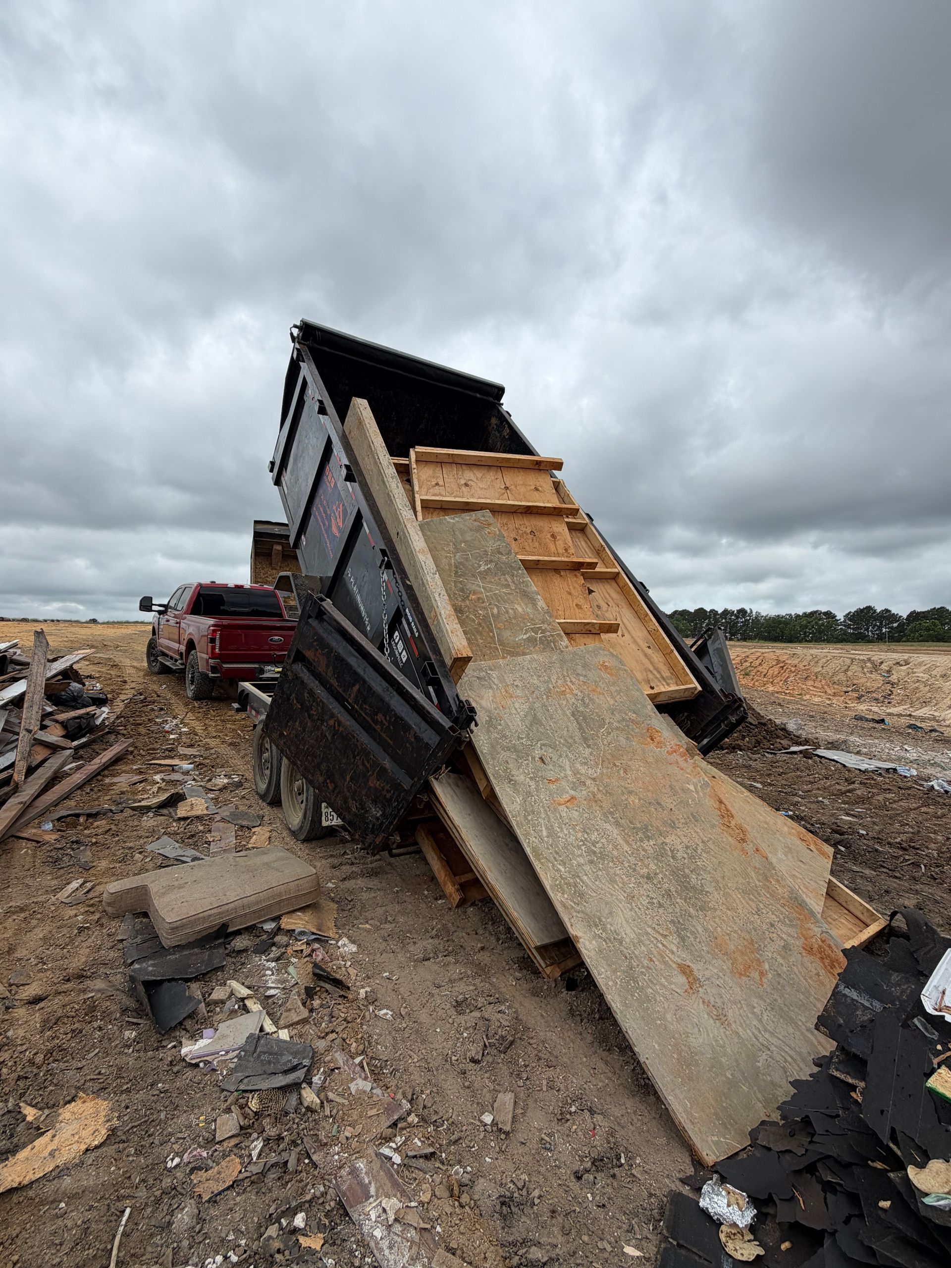 Collapsed building debris with tilted roof panels and rubble under a cloudy sky