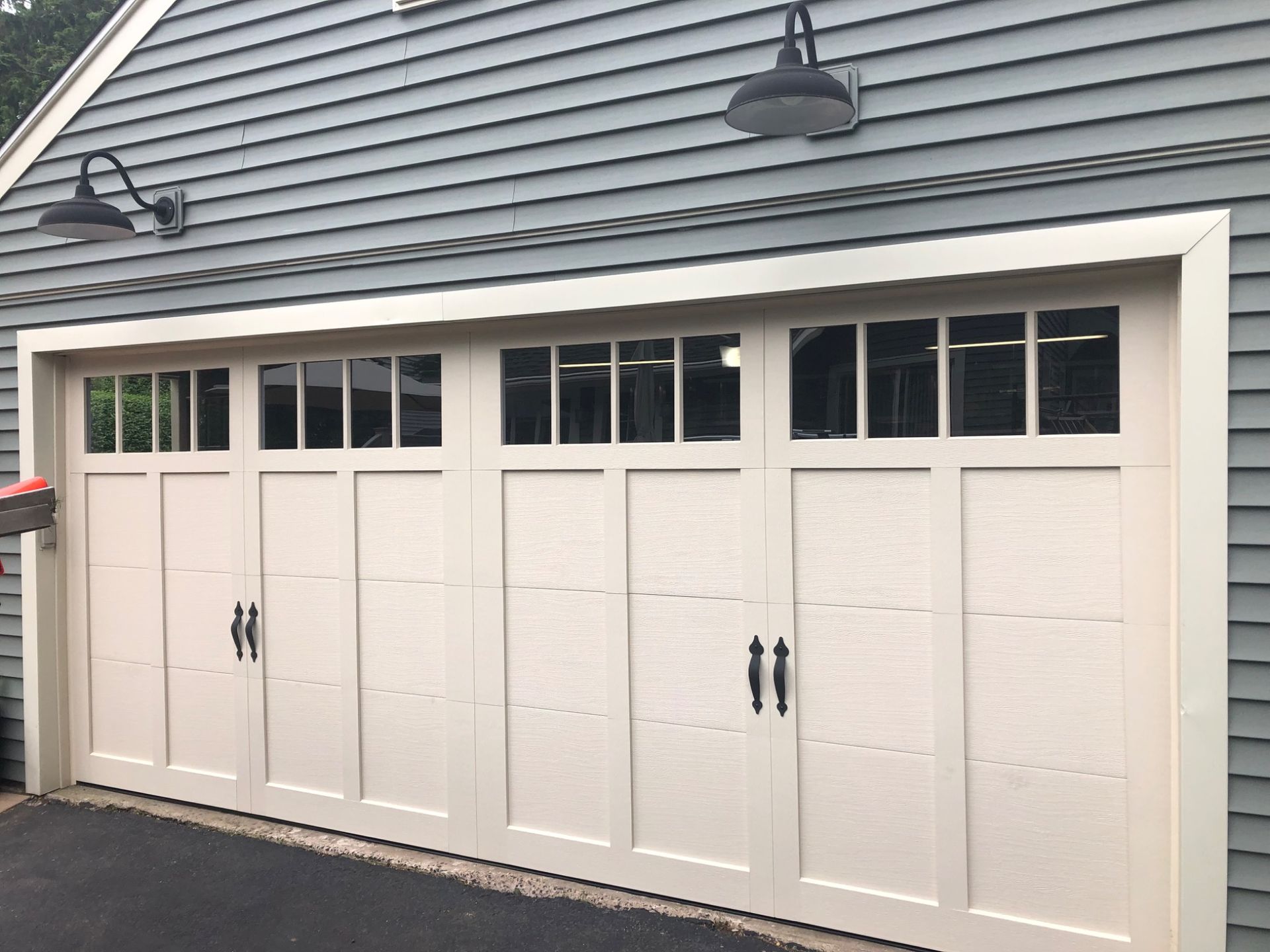 A white garage door is sitting on top of a blue house.