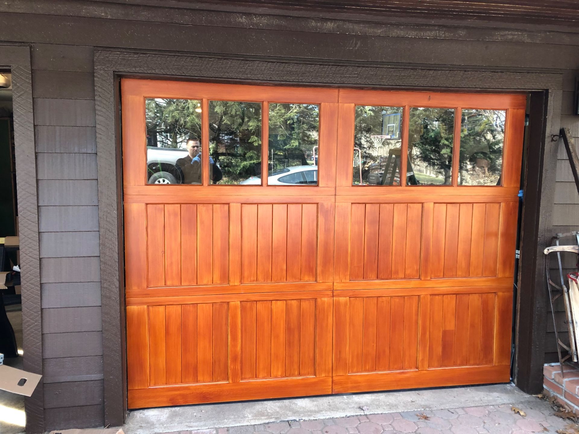 A wooden garage door is sitting on the side of a house.