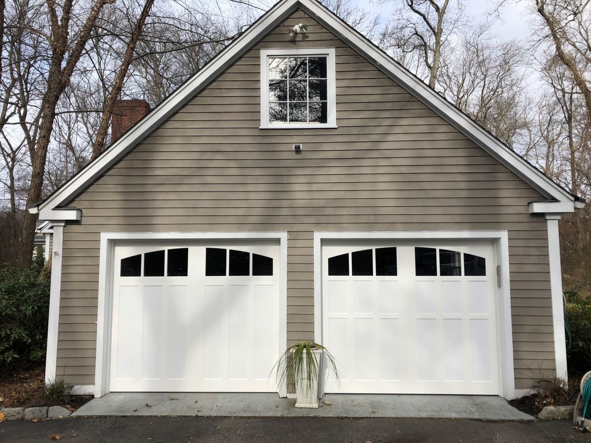 A garage with two white garage doors and a window