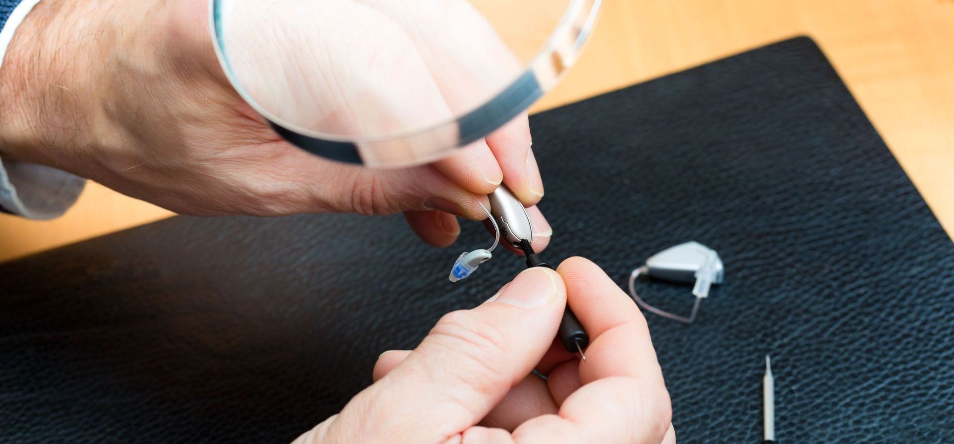 A woman is examining a man 's eye with a magnifying glass.