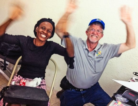 A man and a woman are posing for a picture with their arms in the air