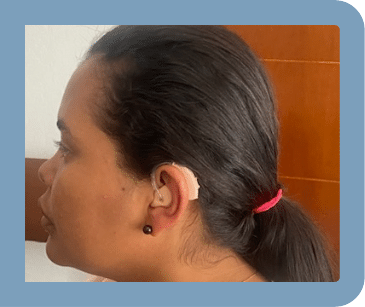 A woman is wearing a hearing aid in her left ear.