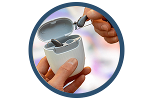 A pair of hearing aids in a case in a circle.