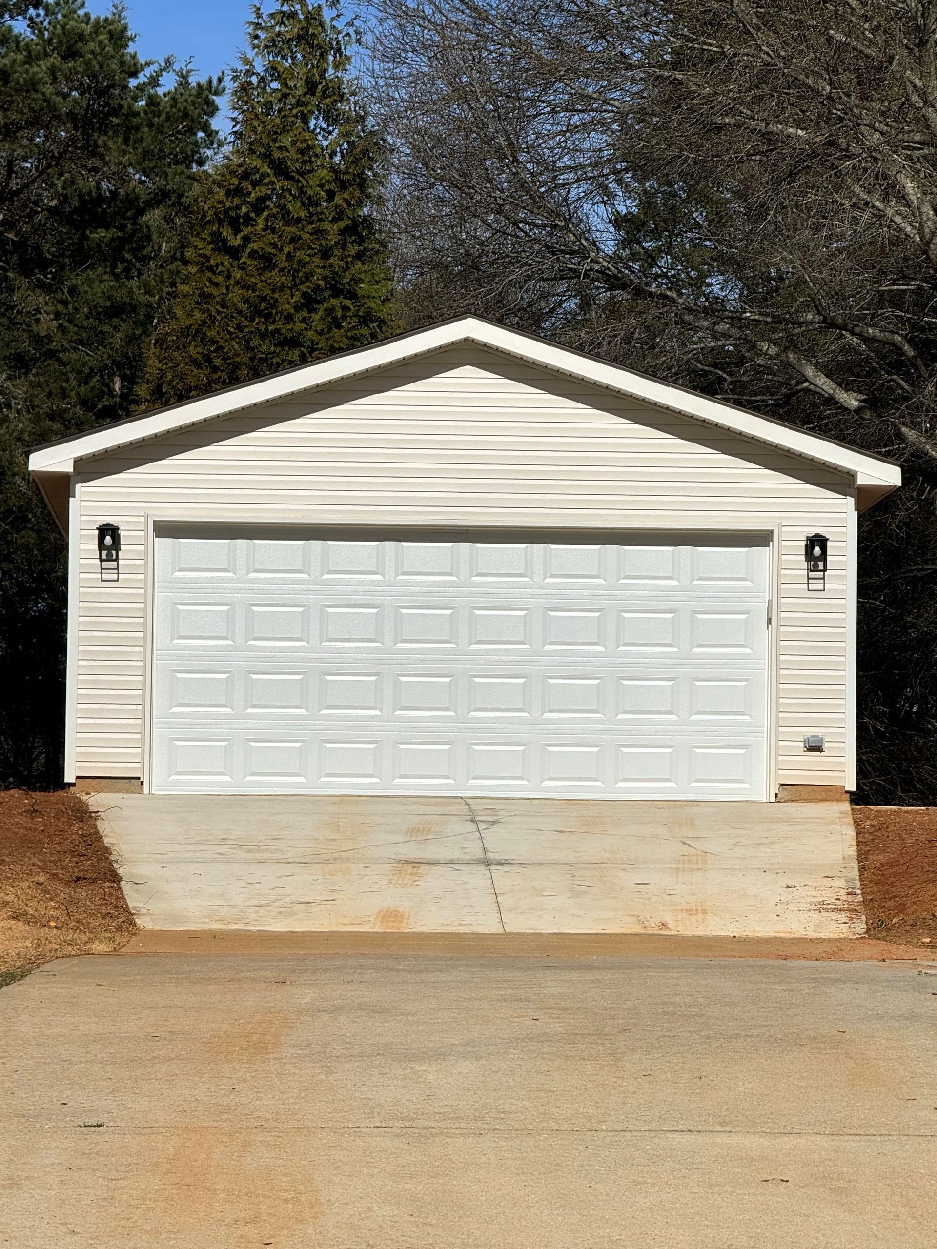 A white garage with a ramp leading up to it.