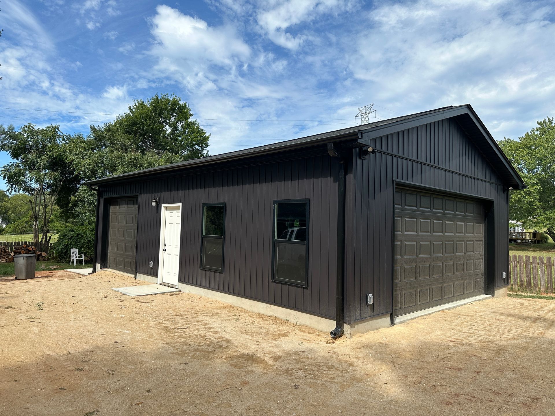 A side view of dark garage with white enhance door two windows with garage door in view.