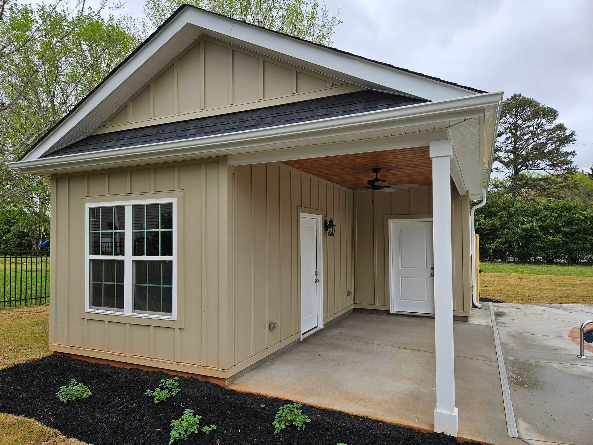 A small house with a covered porch and a ceiling fan.