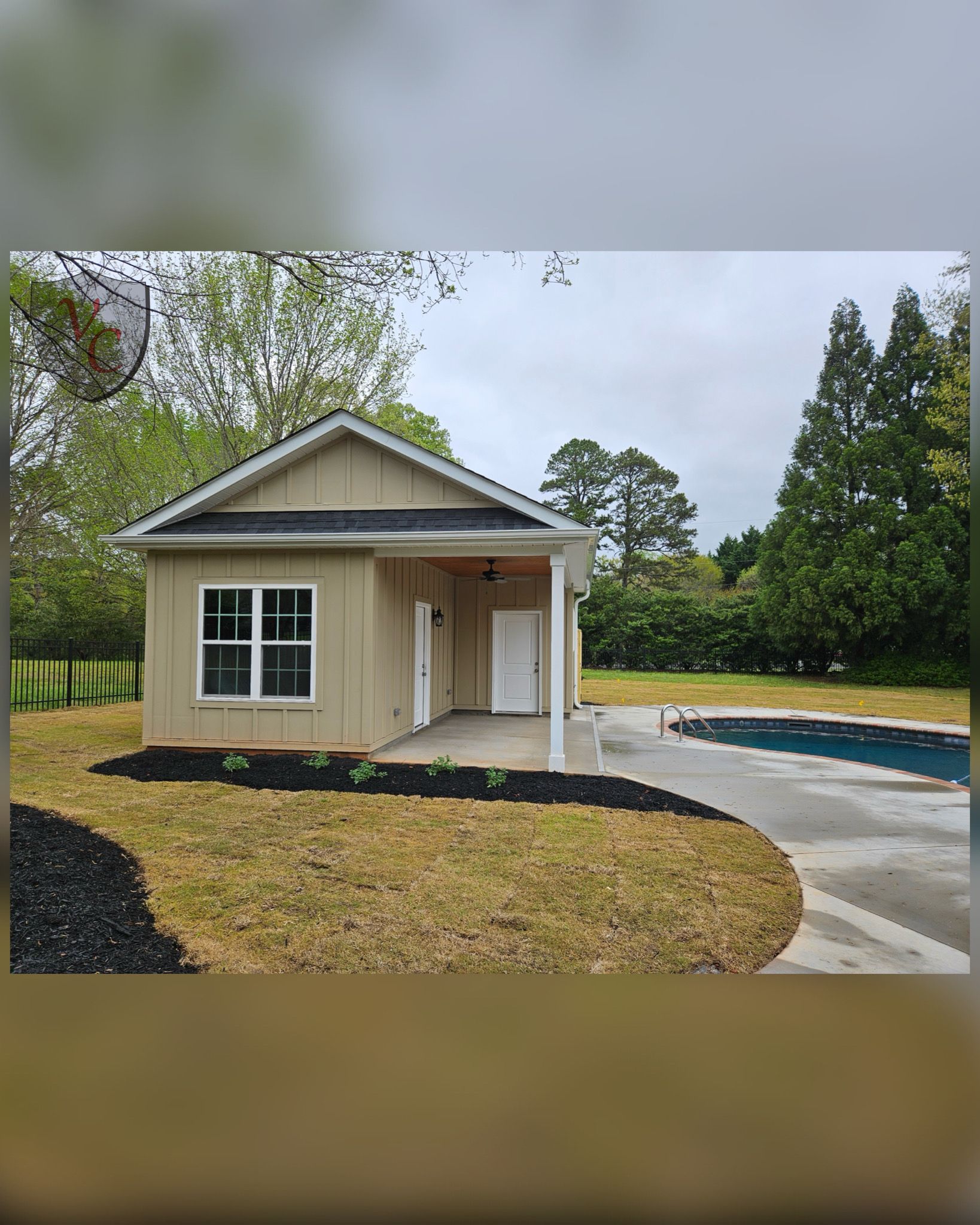 A small house is sitting next to a pool in the backyard.