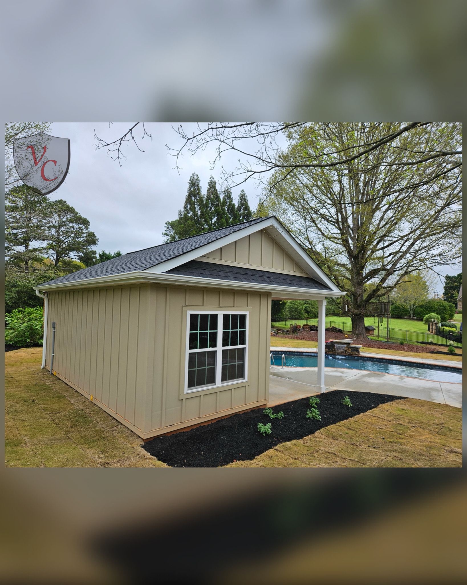 A small shed is sitting next to a swimming pool.