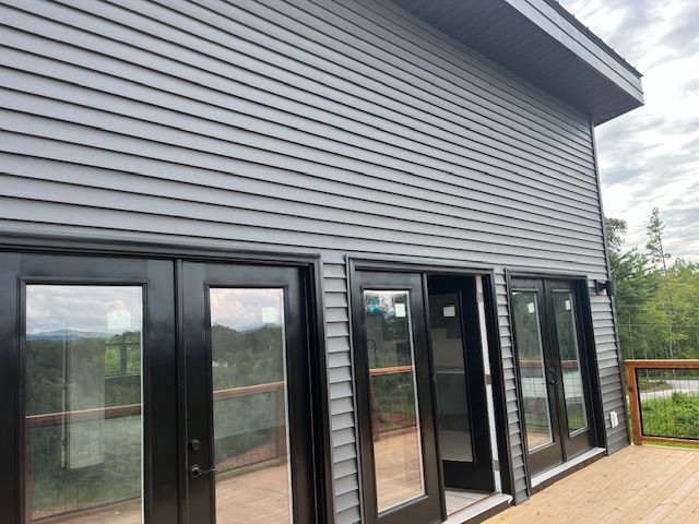 A house with a lot of windows and sliding glass doors.