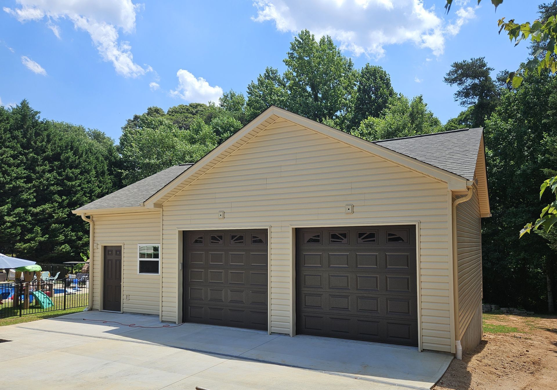 a detached two-car garage with brown doors