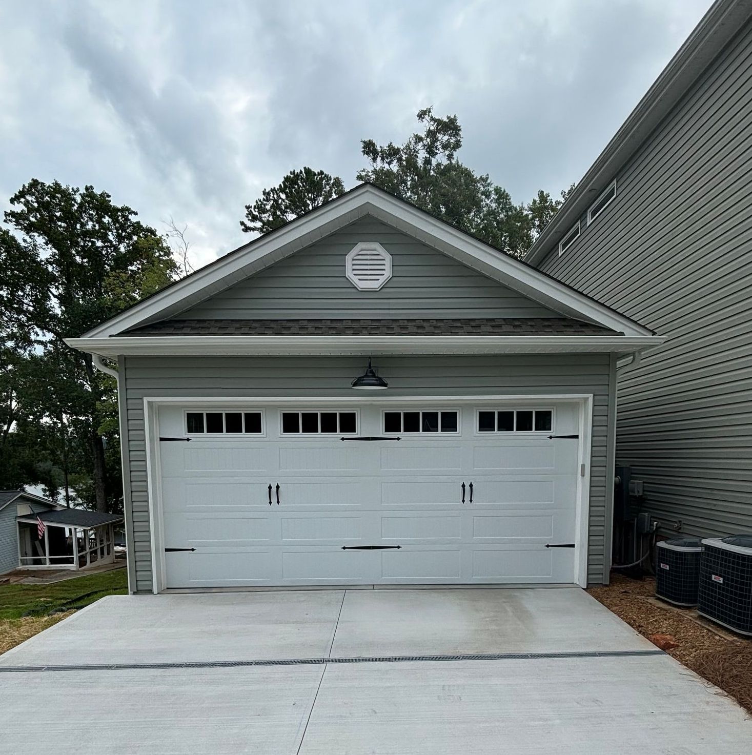 A white garage door is sitting in front of a house