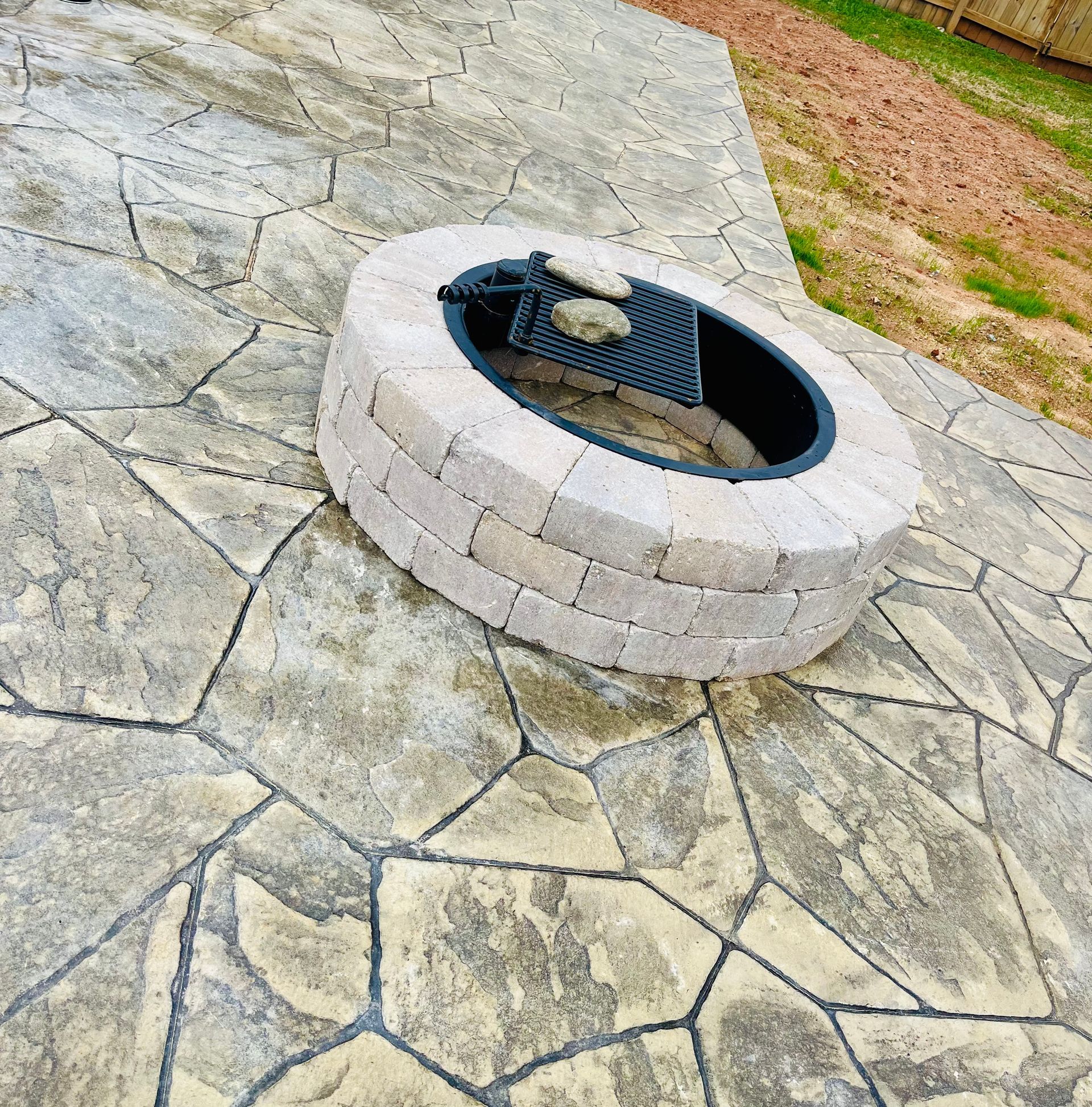 A fire pit is sitting on a stone patio