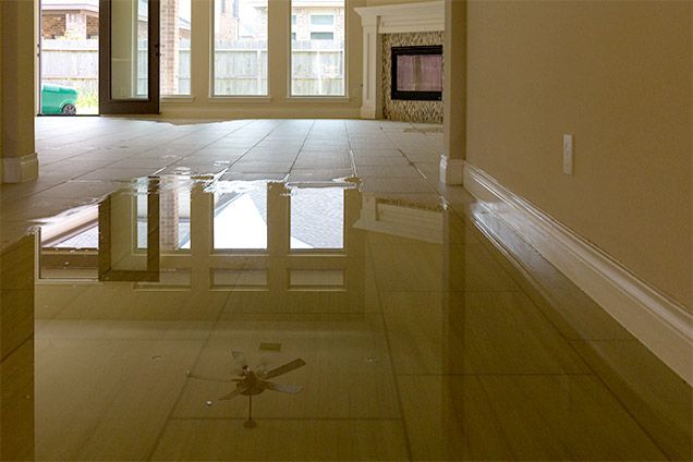 A living room with a flooded floor and a fireplace.