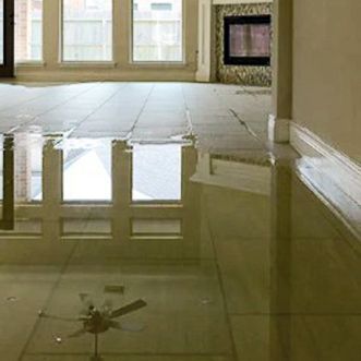 A living room with a flooded floor and a ceiling fan.