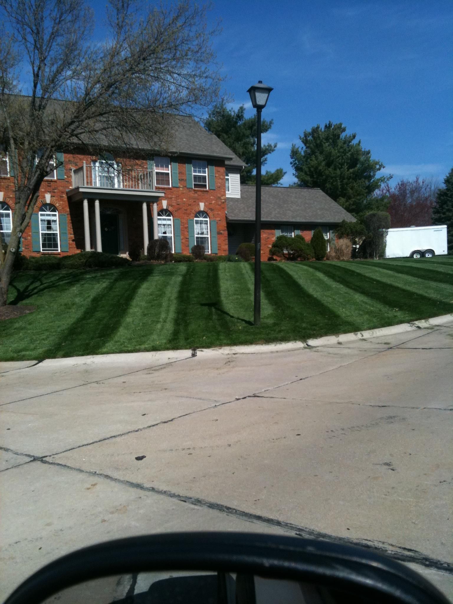 A large brick house with a lush green lawn in front of it