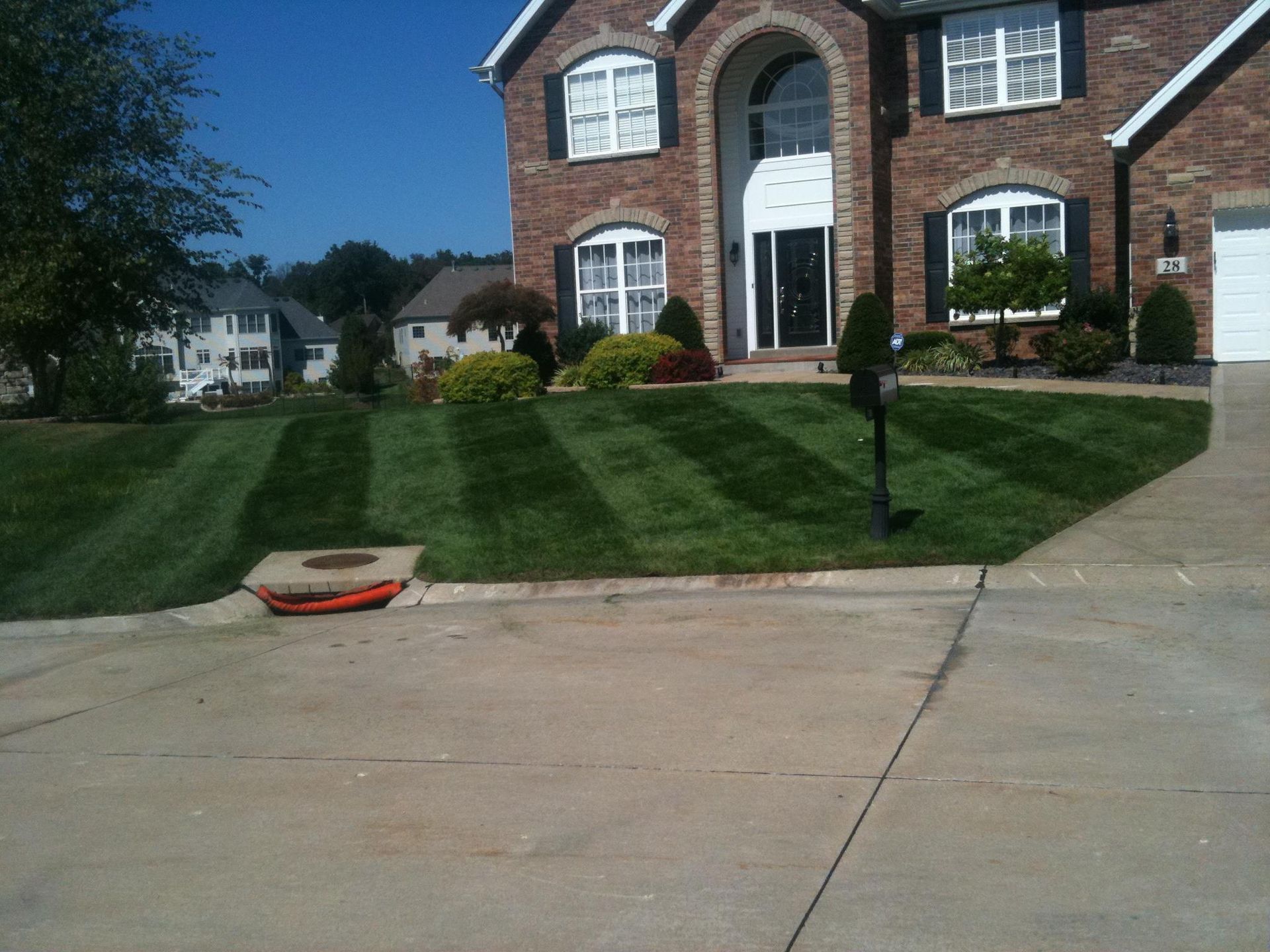 A brick house with a lush green lawn in front of it
