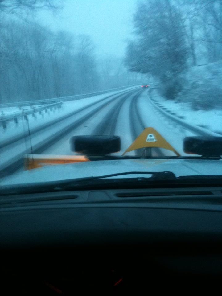 A car is driving down a snowy road.