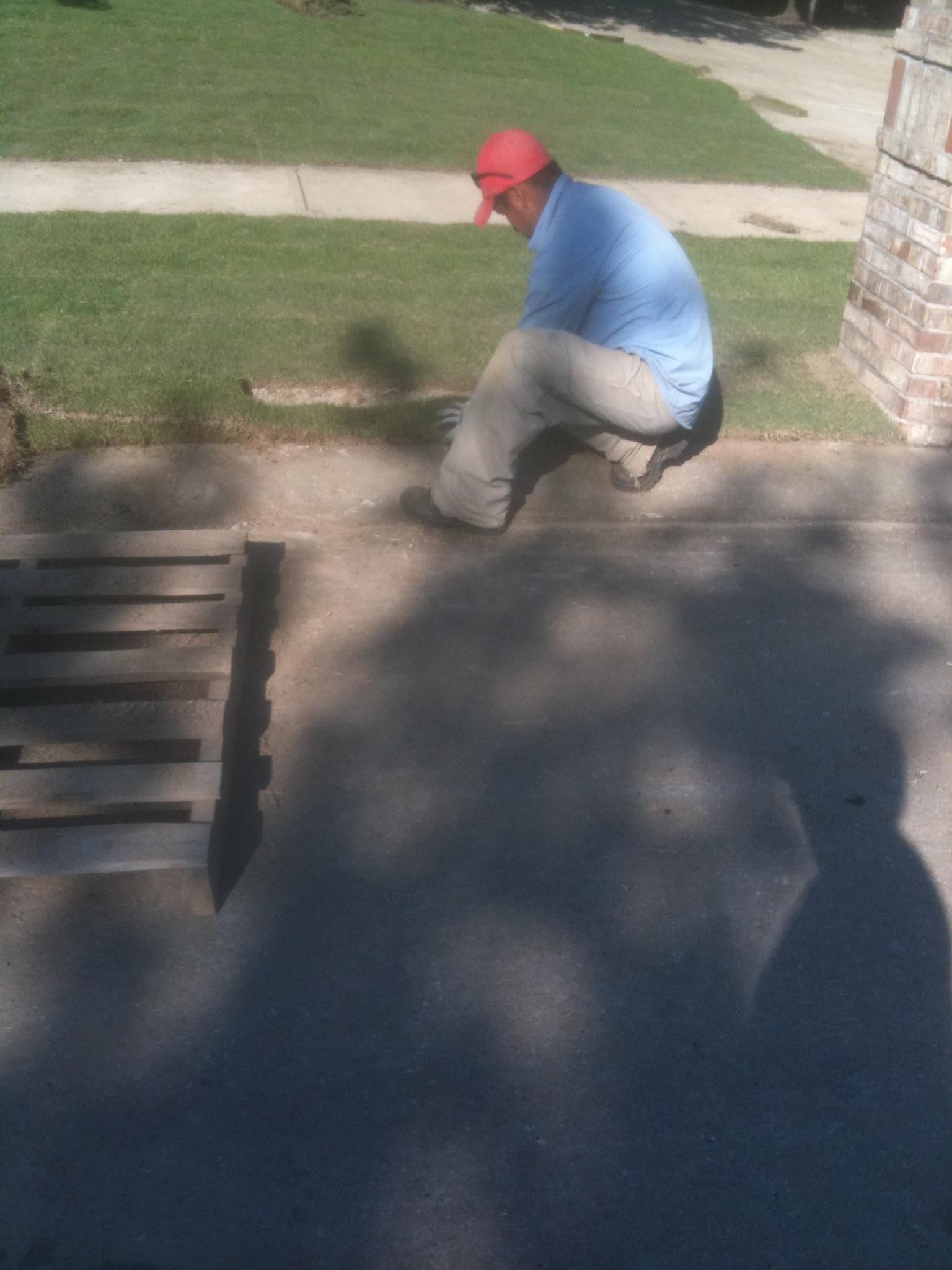 A man wearing a red hat is kneeling down on a sidewalk