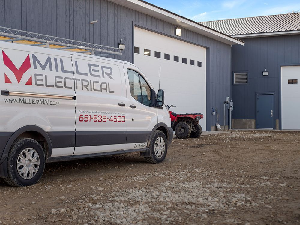 A miller electrical van is parked in front of a building.