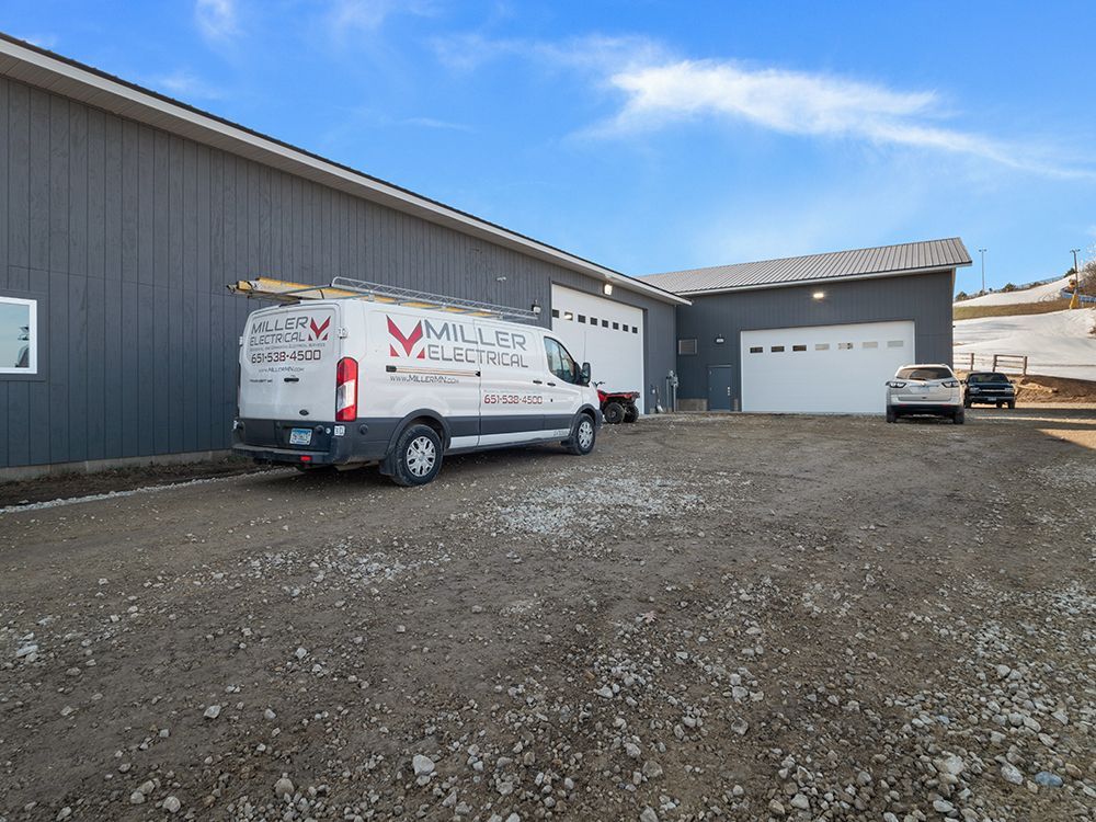 A white miller electrical van is parked in front of a building.