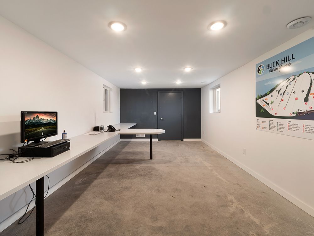 A room with a computer on a desk and a poster on the wall that says seahill