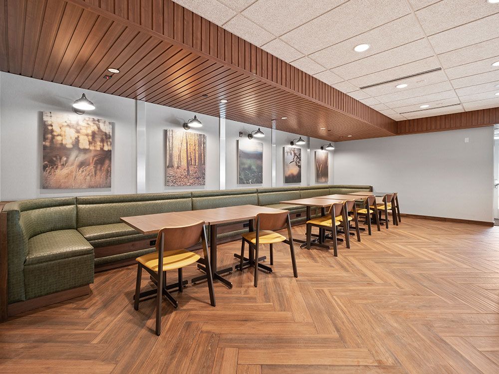 A dining room with tables and chairs and a long bench.