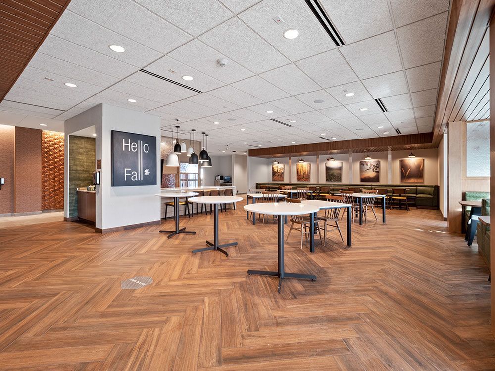 A large room with wooden floors and tables and chairs.