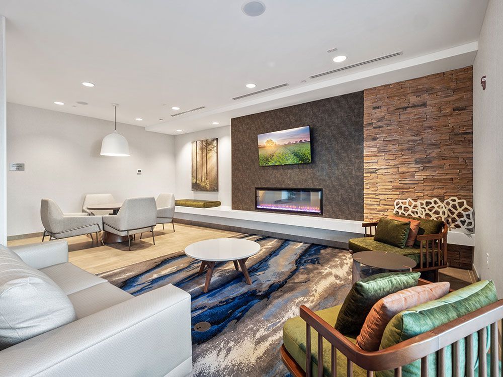 A living room with a couch , chairs , tables and a fireplace.