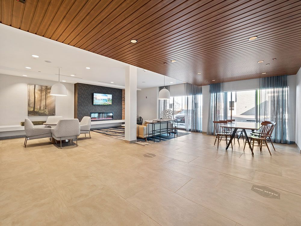 A large room with a wooden ceiling and a table and chairs.