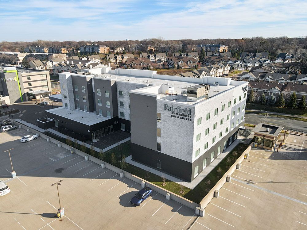 An aerial view of a large building with a parking lot in front of it.