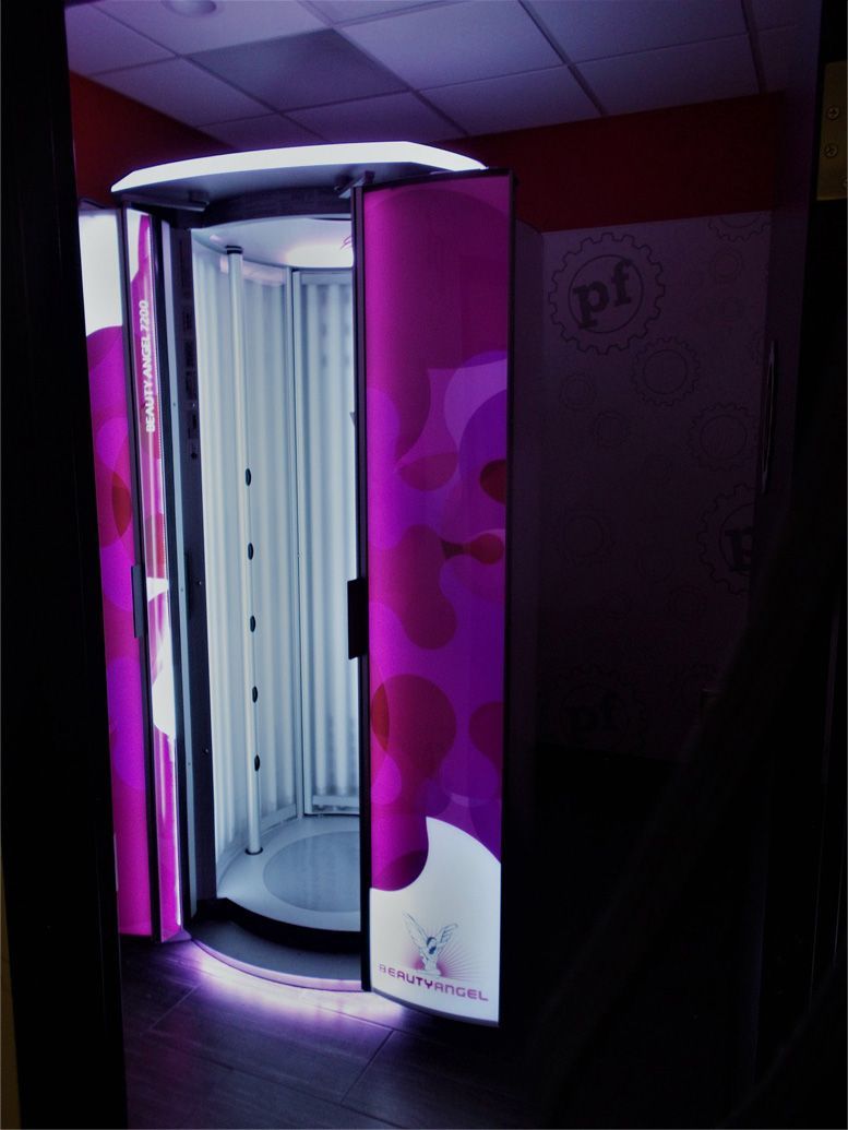 A purple and white tanning booth with the word pf on the wall