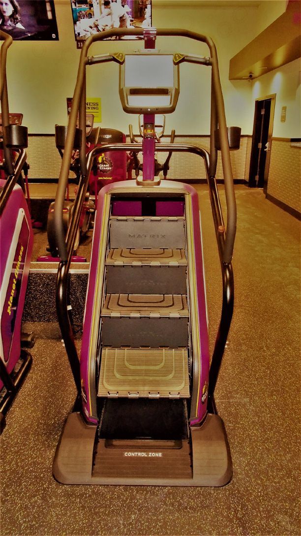 A pink and gray escalator in a gym
