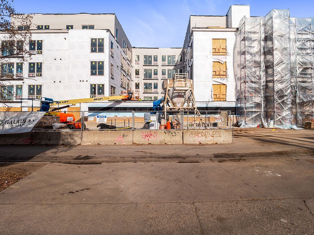 A construction site with a large building in the background.