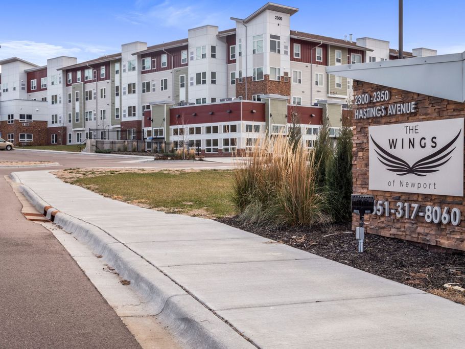 A large apartment building with a sign that says the wings