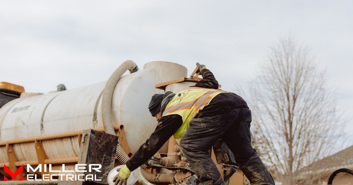 A man in a yellow vest is working on a truck.